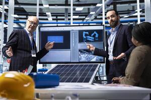 Factory businessmen doing sales presentation for shareholders, showing solar panel solutions. Industrial plant managers showcase product innovations in sustainable energy sector in front of investors photo