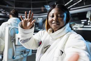 Astronaut wearing spacesuit inside futuristic spacecraft relaying mission data back to Earth. Spaceman transmitting space travel operations data to mission control center back home photo