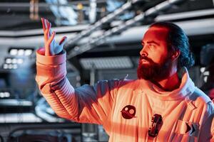 Astronaut reacting to red light alert signals during security breach inside orbital station. Starship crew member responds to unknown threat detected during perimeter scan against hazards photo