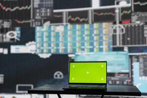 Isolated copy space screen running on laptop next to fintech annual reports, ensuring a strategy for corporate success. Showcasing trends and infographics performance metrics to improve activity. photo