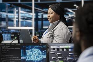 Smiling server room developer using artificial intelligence to enhance operational efficiency and reduce downtime. Happy employee designs and implements AI driven solutions for data center equipment photo