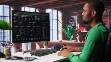 African american software developer does visual coding and creating software, implementing algorithms. IT expert at home working with notes tree and code language, app performance. Camera B. photo