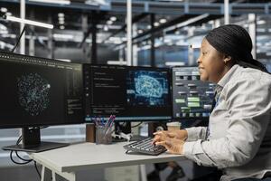 Data center system administrator using machine learning algorithms to analyze large datasets. African american server farm admin using artificial intelligence to recognize data patterns photo