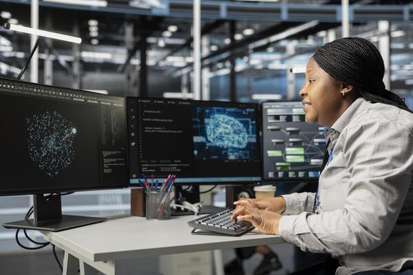 Data center system administrator using machine learning algorithms to analyze large datasets. African american server farm admin using artificial intelligence to recognize data patterns