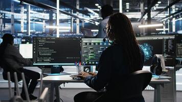 Data center expert examines node tree interface, delivering technical support. Server room technician talking in headset mic with coworkers, using visual programming software, camera A photo