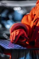 Close up of astronaut typing on laptop keyboard, troubleshooting red light warning triggered by system error. Spaceship cosmonaut using notebook to fix error affecting operations photo