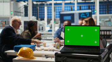 Factory scientists doing research and development, working on manufacturing automation using mockup laptop. Industrial plant experts analyzing technical data on chroma key notebook, camera A photo