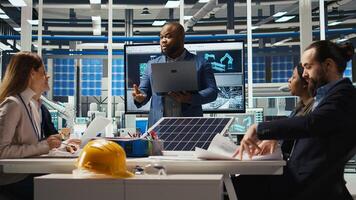Photovoltaics researchers evaluating solar cells to identify weaknesses and improve production. Solar panels factory experts optimizing tech for better energy absorption, camera A photo