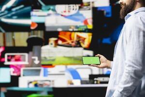 Young influencer checks phone with mockup screen for activity on social media platforms, leveraging innovation and mobile technology to maintain engagement and build a community. Social network. photo