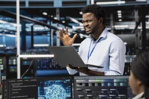 Frustrated technician angered by glitching data center equipment needed to run artificial intelligence and machine learning. Annoyed server room worker irked by errors while using AI tools photo