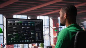 African american software developer does visual coding and creating software, implementing algorithms. IT expert at home working with notes tree and code language, app performance. Camera A. photo