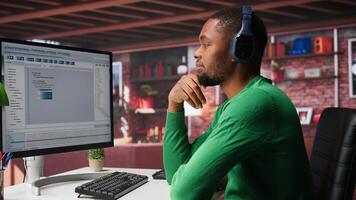 Freelance developer writing code in modern programming language. Young man analyzes data, algorithms and optimizing performance while using binary code at home office. Camera B. photo
