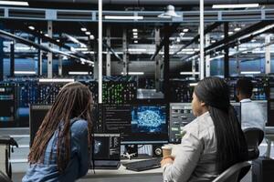 Data center engineering team working together, using AI visualization to oversee automated repetitive tasks. Server farm teamworking colleagues modifying systems based on data analytics graphs photo
