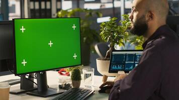 Man reviewing financial graphs on green screen PC, analyzing key performance indicators. Employee looking over data trends and strategic insights on chroma key computer, camera A photo
