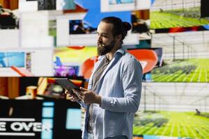 Male cool influencer hosting a live presentation with hands free microphone, engaging an audience to discuss social media reach, digital interaction and creative branding in real time. Trend setter. photo