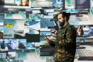 Armed forces soldier gathers surveillance from digital drone systems, preparing for combat with warfare strategies and battlefield details. War planning operations in command center. photo