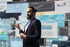 Male entrepreneur taking a phone call to share insight on KPI metrics and evaluate company performance. Specialist using remote communication to improve his profitability, greatness. photo