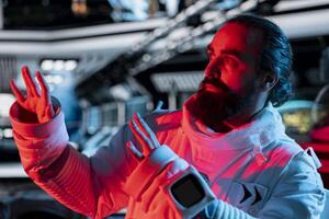 Scared astronaut in spaceship raises hand defensively during alien attack triggering onboard alert. Afraid orbital station crew member reacts to extraterrestrial form disturbance photo