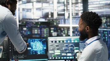 Data center manager praising work done by engineer using neural network models to configure hardware. Supervisor congratulating employee for successfully using AI to optimize system, camera B photo