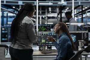 Data center team working together, using AI visualization tool to optimize equipment performance. Server farm coworkers doing brainstorming, using artificial intelligence analysis software photo