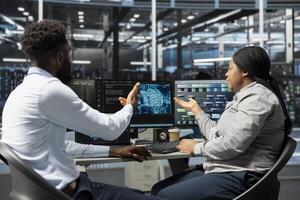 Server room software developers working together using artificial intelligence to reduce downtime. Workplace coworkers design and implement AI driven solutions for data center equipment photo