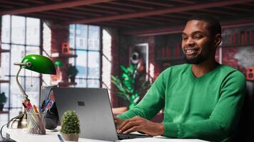 Teleworker at home desk opening laptop to edit documents and solve daily tasks, updating reports and files. Young employee doing remote job and managing digital paperwork. Camera A. photo