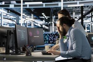 Server room colleagues cooperate to eliminate threats using artificial intelligence tools. Data center coworkers doing brainstorming, reviewing AI systems detecting irregular network activity patterns photo