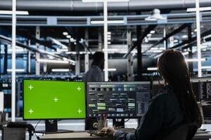 Developer in data center at green screen PC uses AI for machine learning workloads. IT specialist in server hub uses artificial intelligence on chroma key computer to perform demanding computing tasks photo