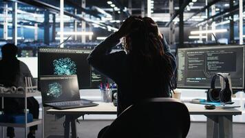 Angry developer frustrated by slow data analytics AI generator. Annoyed data center worker punching desk, irked by glitching artificial intelligence program showing system metrics, camera A photo