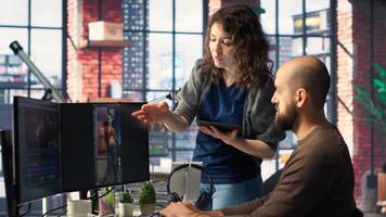Man and woman collaborate on content creation for the media industry, analyzing data and insights, editing footage and adjusting branding elements. AI powered. Camera B. photo