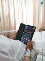 Patients monitor the Nasdaq composite index via tablets in their hospital beds. Planning investments take profit, trade stock exchange market and cryptocurrency data, financial. photo