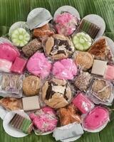 A colorful assortment of Traditional Indonesian Kue Snacks in a tampah lined with banana leaves. For a new housewarming event. Snack for takjil or break fasting during Ramadan. photo