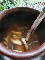Close-up of a clay pot with homemade Kolak. Kolak is usually one of the menus for breaking the fast during the month of Ramadan. Made from bananas, palm sugar, cinnamon, cloves and pandan leaves. photo