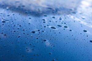 Water droplets accumulate on a blue surface after rainfall during early morning hours photo