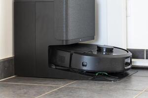 Robot vacuum cleaner with dust, real life photo, saves time and goes into hard-to-reach places, room photo