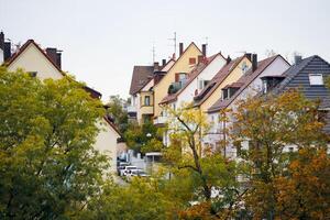 The houses stand one after the other, creating a domino effect. A picturesque view from the roof level of the cascade of houses with tiled roofs. photo