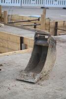 Preparation for foundation filling. A bucket for digging foundations. The iron bucket of the excavator lies on the ground. photo