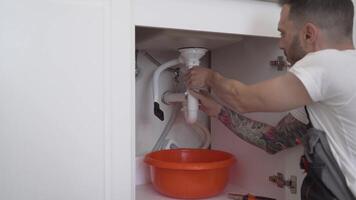 Handyman Fixing Broken Siphon Pipe in Kitchen with Tools video