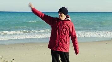 Man in a Jacket Waves to People by the Sea video