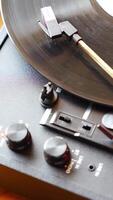 Close-up of record player needle tracking vinyl grooves during playback. Analog sound detail capturing retro music atmosphere. Vertical . High quality 4k footage video