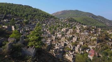 aéreo foto. ver de un pueblo con muchos abandonado casas en el montañas video