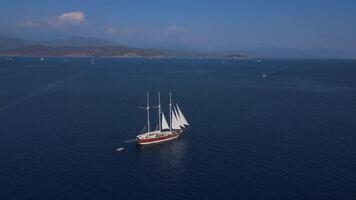 Sailing through majestic blue ocean timeless scene of sailboat gracefully gliding across vast expanse of deep blue ocean. Ship billowing sails catch wind propelling it forward through endless sea. video