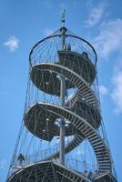 Stuttgart, Germany 20 Mai 2025. The spiral iron tower in Stuttgart. A spiraling metal staircase ascends into a bright blue sky, showcasing a modern architectural design against a serene backdrop. photo