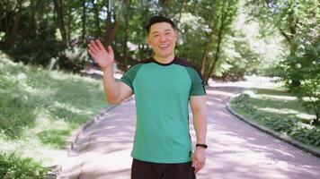 Athletic runner sport man waving hi hello welcome with hand greeting with hospitable friendly smile video