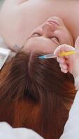 Trichologist doing woman hair regeneration procedure, dermapen microneedling, vitamin injections video