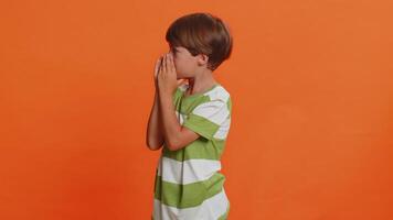 Child boy kid holding hands near mouth loudly screaming, shouting, yelling welcomes someone hello video