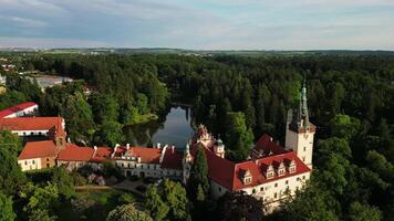 Aerial close orbiting view of Pruhonice chateau with pond and park in May 2025 in Czechia video