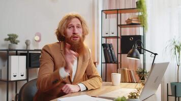 Business man working on laptop shakes finger and saying No be careful mistake disapproval sign video