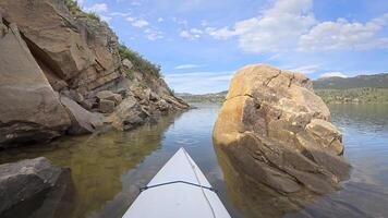 spring canoeing in a sandstone canyon along a rocky shore of Horsetooth Reservoir near Fort Collins, Colorado - POV paddler perspective photo