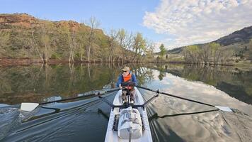 rowing scenery from a calm lake at foothills of Rocky Mountains with a senior rower photo